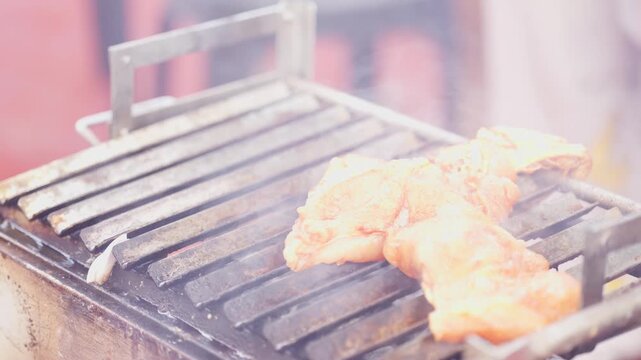 Hand Placing Chicken Pieces on Empty Barbecue Grill Grate to Start Cooking Close Up