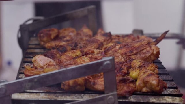 Close Up of Hand Continuously Basting Seasoned Grilled Chicken with Juice and Sauce on BBQ Grill