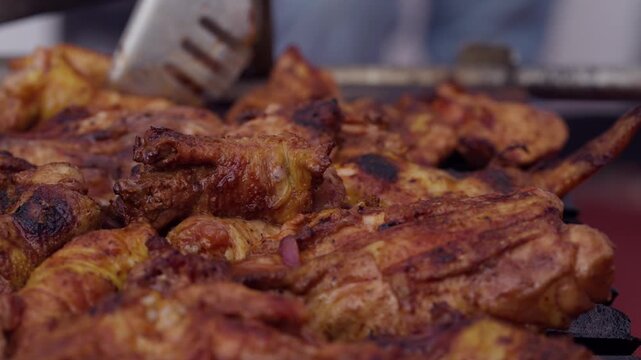 Extreme Close Up Macro of Hand Turning Perfectly Cooked Golden Barbecue Chicken on Grill