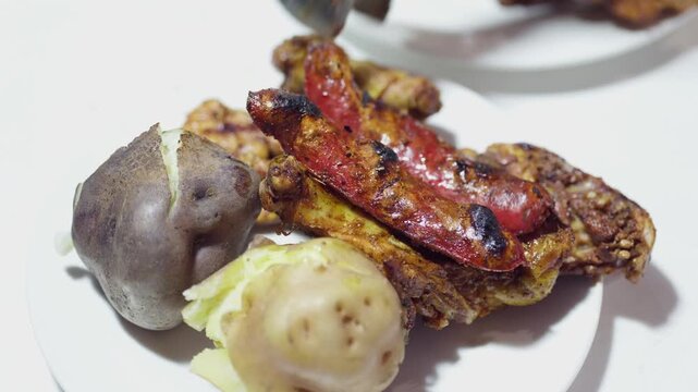 Close Up of Served Peruvian Pollada with Grilled Chicken Chorizo Sausage and Potatoes on Plate