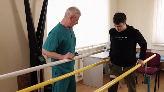 physical therapist, walking rehabilitation, recovery process. Patient practices walking with aid of parallel bars in bright rehabilitation facility.