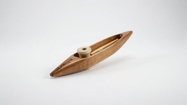 Handcrafted wooden weaving shuttle with a wooden bobbin and dowel tool