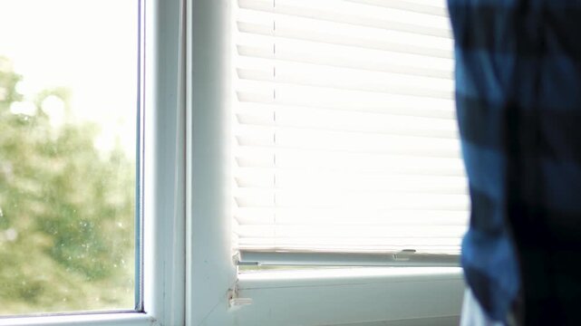 Low angle shot of a man hand washing window glass with a soapy sponge