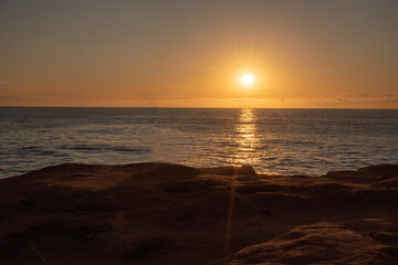 Obraz premium Sunrise Over Atlantic Ocean with Golden Light and Calm Sea