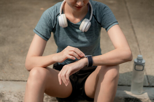 Young woman runner checking smartwatch after jogging in park, tracking fitness progress with headphones and sportswear, healthy outdoor lifestyle concept, runner, smartwatch, jogging, park, workout,