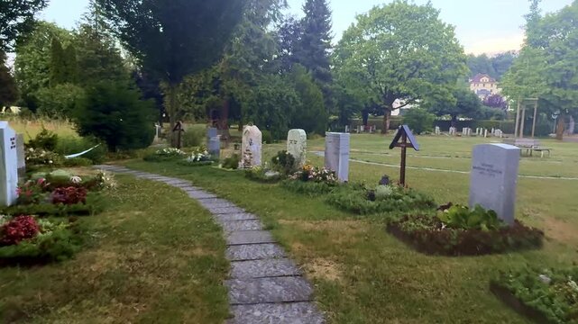 Quiet Graveyard With Rows Of Tombstones Fresh Flowers And Candles In Soft Morning Light