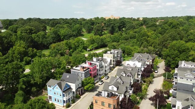 Aerial flyover shot of colorful new homes near downtown Raleigh with Dix Park in the distance