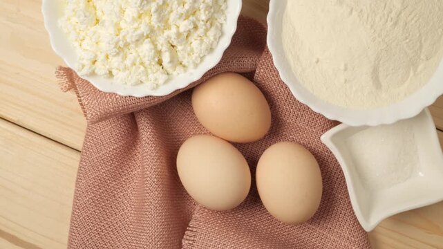 Fresh baking ingredients rotating on a wooden table