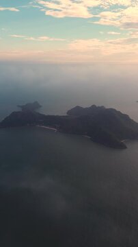 Stunning aerial footage flying over a tropical island archipelago during a hazy and colorful sunset