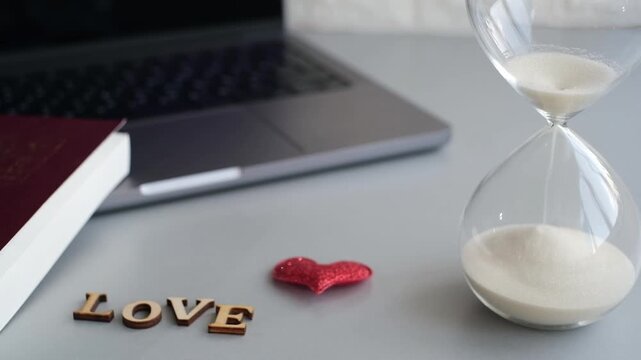 Timer and love letters on a table with a laptop nearby in a cozy indoor setting