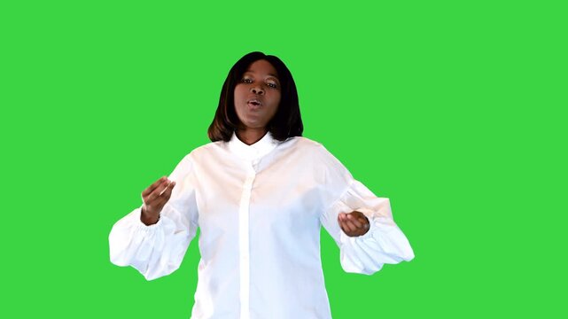 Inspired african american female soul singer dances slightly snapping fingers on a Green Screen, Chroma Key.