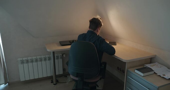 Kid Boy Doing Homework in Workbook Writing with Pen on Table Desk. 4K 10-bit