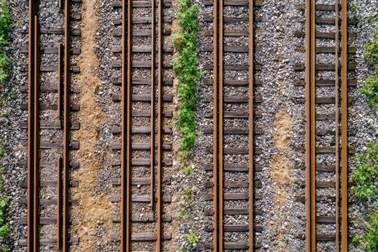 Aerial view of multiple parallel train tracks with gravel ballast and green vegetation