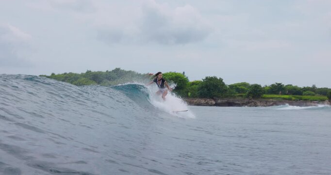 Surfer girl riding on surfboard during surfing. Female surfer rides on wave