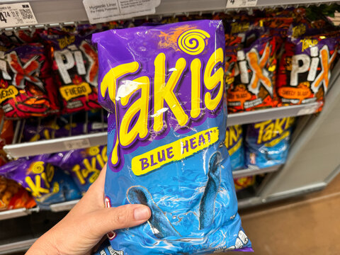 Mesa, Arizona - June 28, 2026: Hand holds a package of Takis Blue Heat flavored chips at Walmart