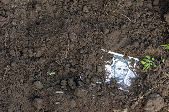 Buried Five-Dollar Bill Symbol of Devalued Money