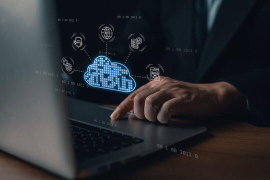 Close up of businessman hand touching laptop trackpad with virtual cloud computing network graphic for digital server storage, information transfer, and database security solution.