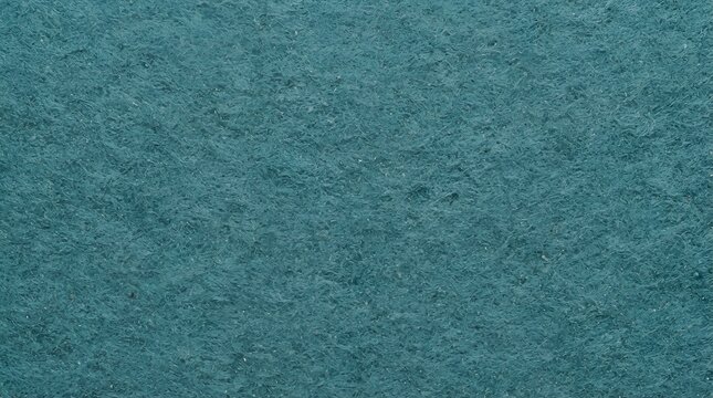 Close up of deep teal colored paper texture showing fibrous details and a rough matte surface for artistic backgrounds and print projects