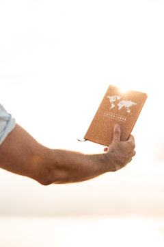 vertical Person holding adventures journal with a world map