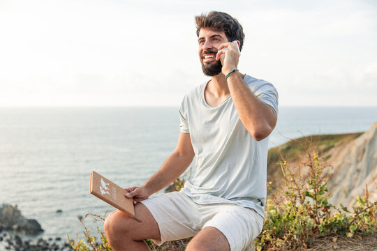 Man talking on phone, dreaming of travel and adventure