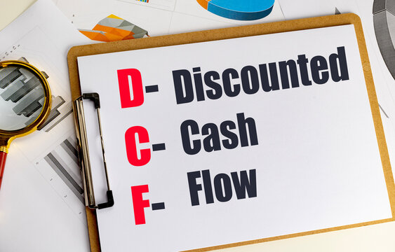Discounted cash flow dcf acronym on clipboard with financial charts and magnifying glass representing business valuation investment