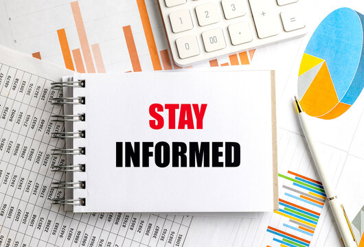 Stay informed message on notepad with financial charts calculator and pen representing business analytics market research