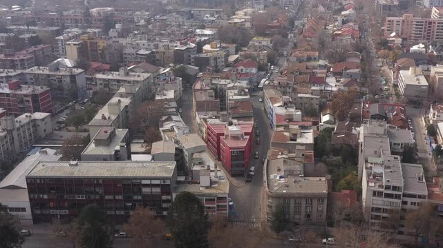 Aerial view of a unique triangular red residential building at a street intersection in Santiago de Chile