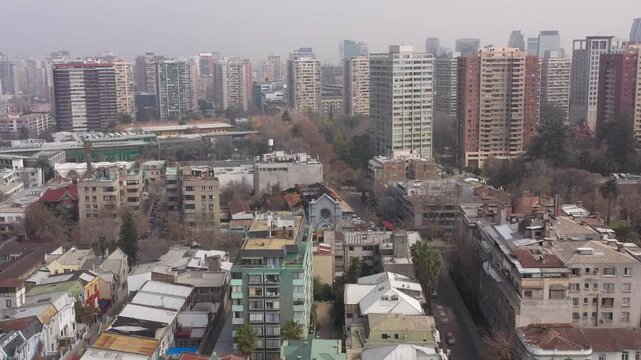 Aerial view of a unique triangular red residential building at a street intersection in Santiago de Chile