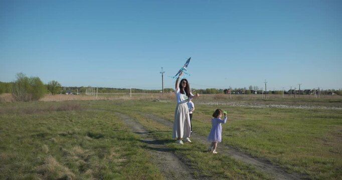 Children with mother flying a kite. Family spend time together on nature. 4K 10-bit