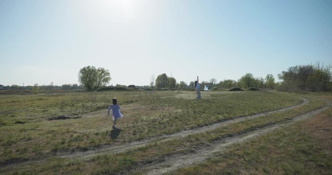 Children with mother flying a kite. Family spend time together on nature. 4K 10-bit