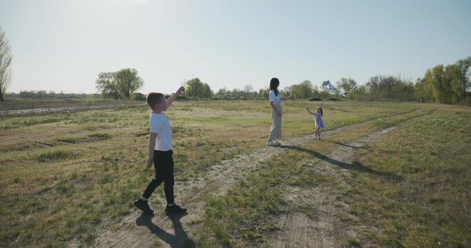 Children with mother flying a kite. Family spend time together on nature. 4K 10-bit