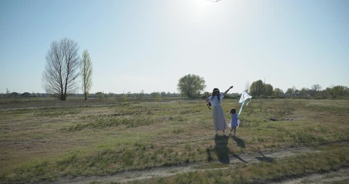 Children with mother flying a kite. Family spend time together on nature. 4K 10-bit