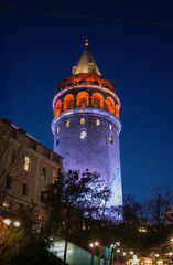 Obraz premium Galata Tower illuminated in vibrant colors against deep blue evening sky