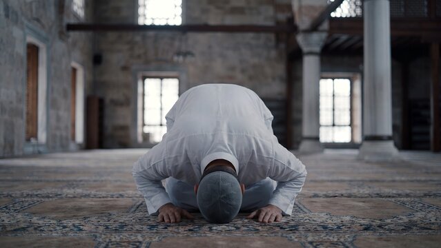 Muslim man performing prostration prayer in tarditional mosque demonstrating Islamic worship, faith practice and spiritual devotion