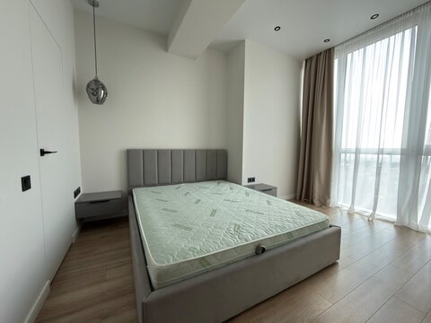 Modern Minimalist Bedroom Interior with Upholstered Bed and Large Window