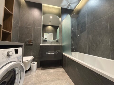Modern Luxury Bathroom Interior with Bathtub Washing Machine and Vanity