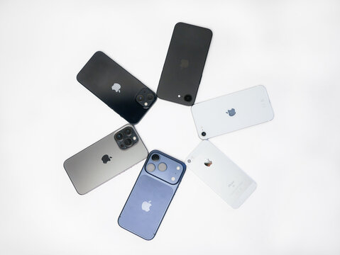 Vienna, Austria - 17 July 2026: Collection of Apple iPhones from different generations (17 Pro, 16, 15, 13 Pro, SE, 5S) arranged in a circle on white background, smartphone evolution concept