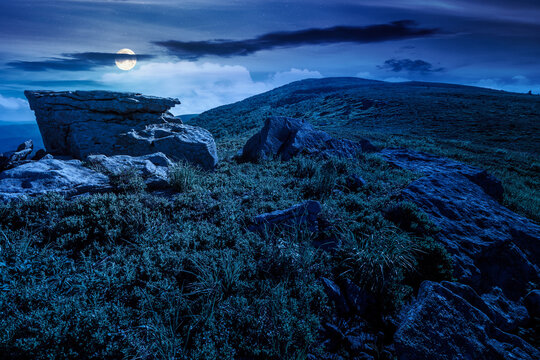 mountain landscape in summer at night. mysterious outdoor scenery of carpathian mountains. full moon over grassy slopes with rocks. fantasy image for ukraine travel background