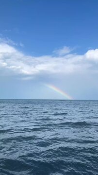 Bright Rainbow Touching Ocean Horizon