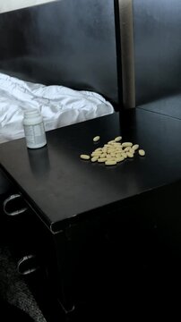 Hand Near Pill Bottle on Bedside Table
