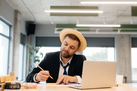 Businessman in straw hat dreaming of tropical vacation
