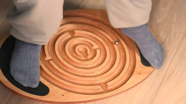 Wooden balance board with built in maze and rolling marble designed for children and adults, improving coordination, balance, focus and problem solving through interactive skill based exercise.