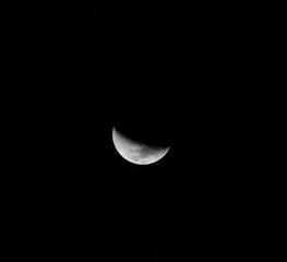 Sharp Crescent Moon in Pitch Black Night Sky: A high-contrast, close-up photograph capturing a crisp, bright silver crescent moon suspended in a completely dark, pitch-black night sky. The clean, mini © Abraham