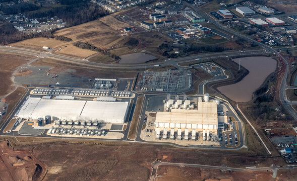 Sterling, Virginia, USA - January 8, 2024 -Aerial view of Google's Arcola 1 and Arcola 2 data centers at the Arcola Campus, showing cooling infrastructure and an adjacent electrical substation 