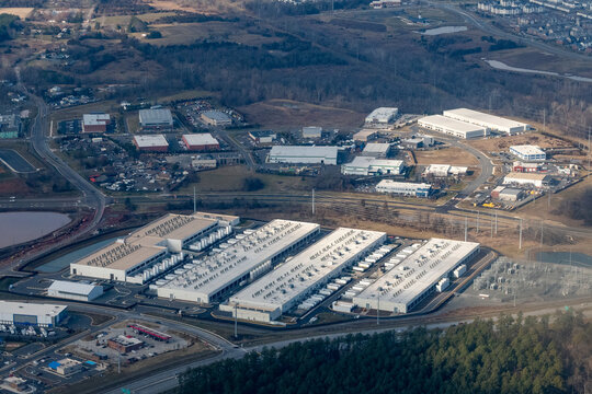 Sterling, Virginia, USA - January 8, 2024 - Aerial view of Amazon Web Services' Fadeley Campus data centers and an adjacent electrical substation near Arcola Boulevard surrounded by warehouses