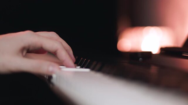 Pianist playing classical music on piano. Musician pressing keys on musical instrument. Melodic performance in dark studio with soft glowing warm bokeh backlight.