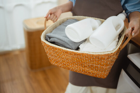 Laundry, basket, and detergent scene featuring fabric and softener in a contemporary setting, lifestyle, efficiency, organized, residential, neat, utility, load, sanitation, chore.