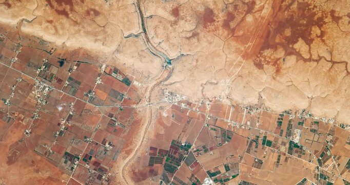 View from above on wadi in desert. Camera is zooming out, rotating counterclockwise. Animation based on image by NASA
