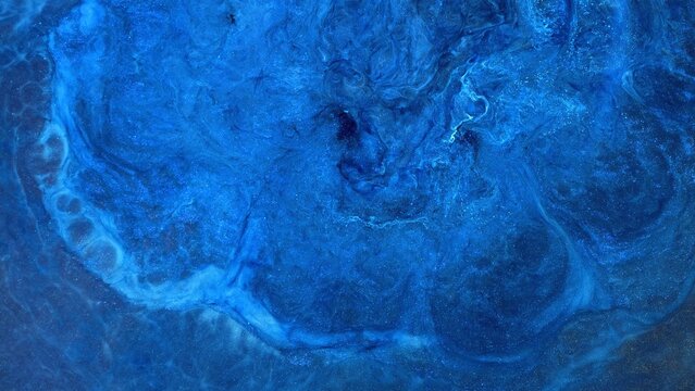 Mixing different colors of alcohol ink on a surface in a creative space