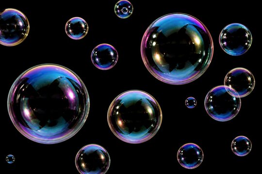 Soap bubbles floating against dark reflective background